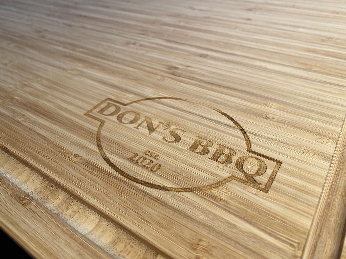 Bamboo cutting board engraved with a restaurant logo