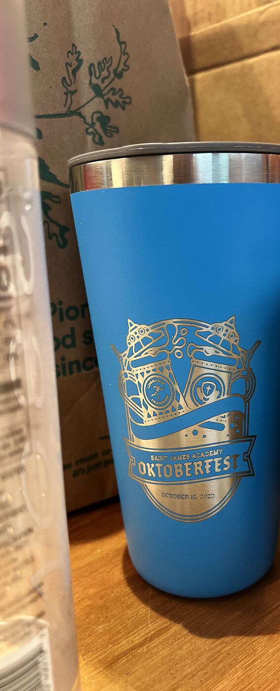 Blue tumbler engraved with a crest logo